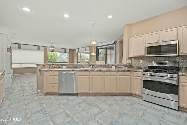 kitchen with light tile patterned floors, appliances with stainless steel finishes, backsplash, and kitchen peninsula