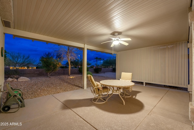 patio terrace at dusk featuring ceiling fan