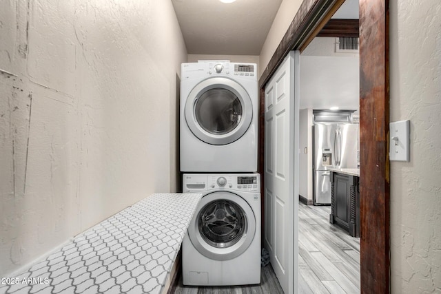 7126 N 19th Ave Unit 228, Phoenix, AZ 85021 - washroom featuring stacked washer / drying machine, light wood-type flooring, and a textured wall