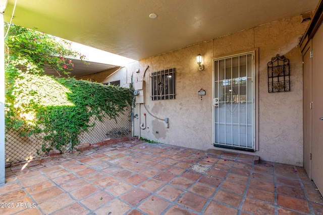 7126 N 19th Ave Unit 228, Phoenix, AZ 85021 - view of exterior entry with stucco siding and a patio