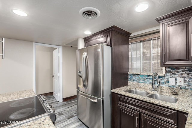 7126 N 19th Ave Unit 228, Phoenix, AZ 85021 - kitchen featuring stainless steel appliances, dark brown cabinetry, light wood-type flooring, tasteful backsplash, and recessed lighting