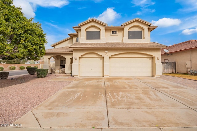 mediterranean / spanish house featuring a garage, driveway, a tiled roof, fence, and stucco siding