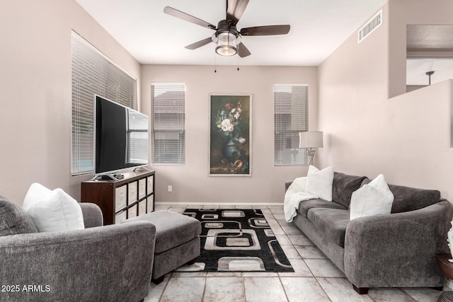 living room featuring ceiling fan, visible vents, and baseboards