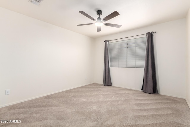 spare room with baseboards, visible vents, a ceiling fan, and carpet flooring