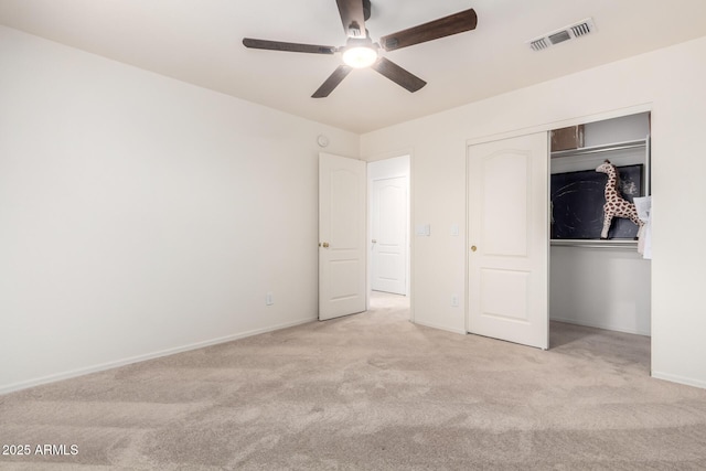 unfurnished bedroom with light colored carpet, ceiling fan, and a closet