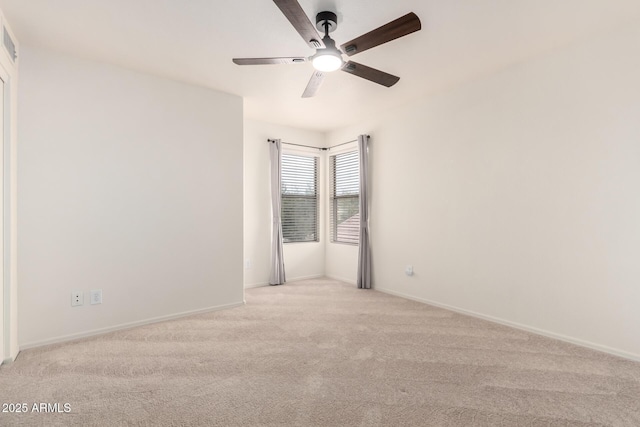 empty room with ceiling fan, baseboards, and light colored carpet