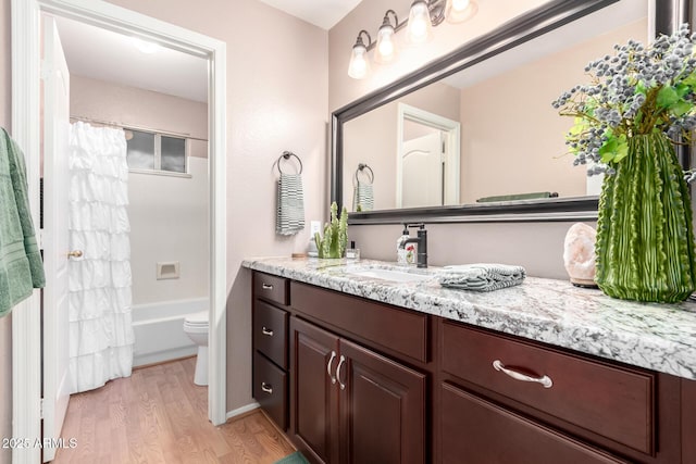 full bathroom featuring vanity, hardwood / wood-style floors, shower / tub combo, and toilet