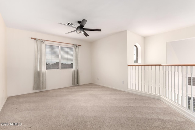 carpeted spare room with visible vents, plenty of natural light, and a ceiling fan