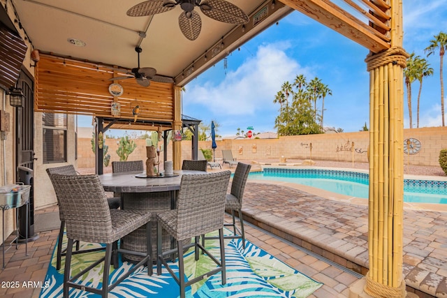 view of patio / terrace featuring ceiling fan, exterior bar, and a fenced in pool