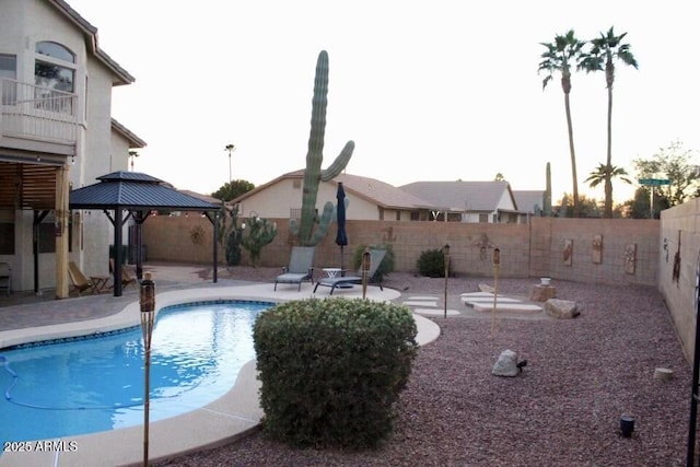 view of pool featuring a fenced in pool, a fenced backyard, a patio, and a gazebo