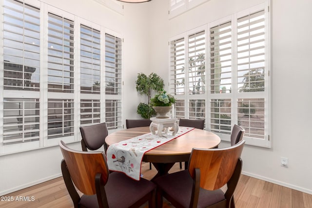 dining space featuring baseboards and wood finished floors