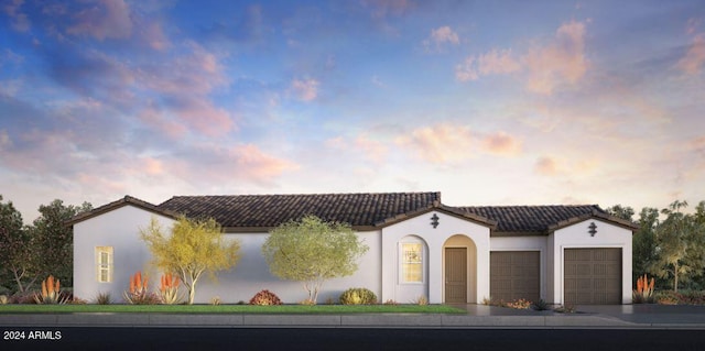 mediterranean / spanish-style house with a tile roof, a garage, and stucco siding