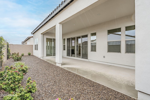 back of house featuring stucco siding, a patio, and fence