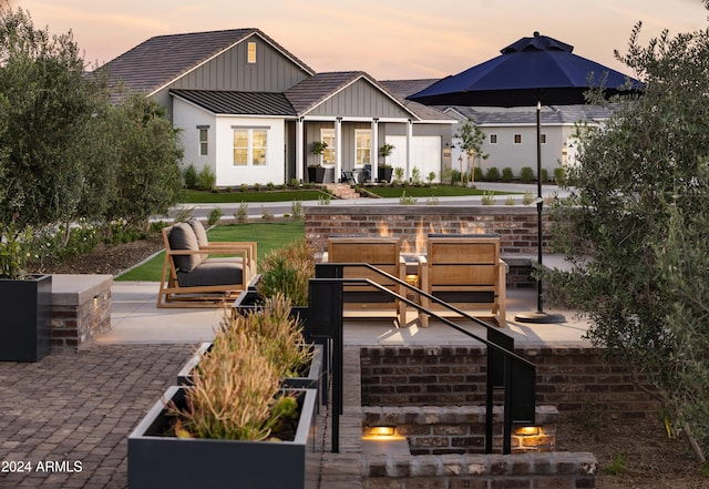 back of house featuring board and batten siding, metal roof, a standing seam roof, and a patio