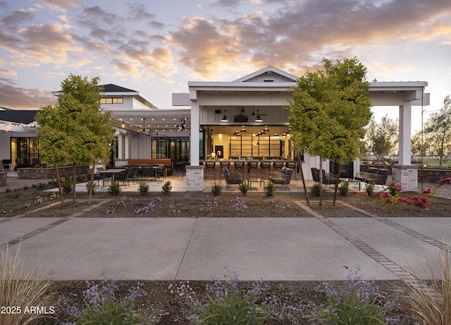 back of property at dusk featuring a patio and a ceiling fan