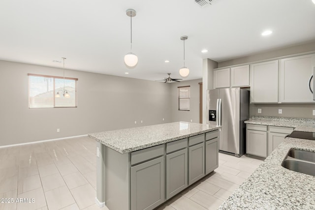 9822 W Caron Dr, Peoria, AZ 85345 - kitchen featuring stainless steel fridge, a center island, recessed lighting, hanging light fixtures, and light stone counters