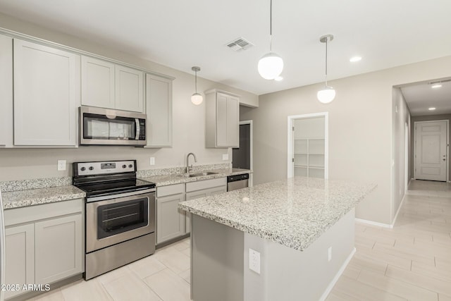 9822 W Caron Dr, Peoria, AZ 85345 - kitchen featuring appliances with stainless steel finishes, a sink, a kitchen island, light stone countertops, and recessed lighting
