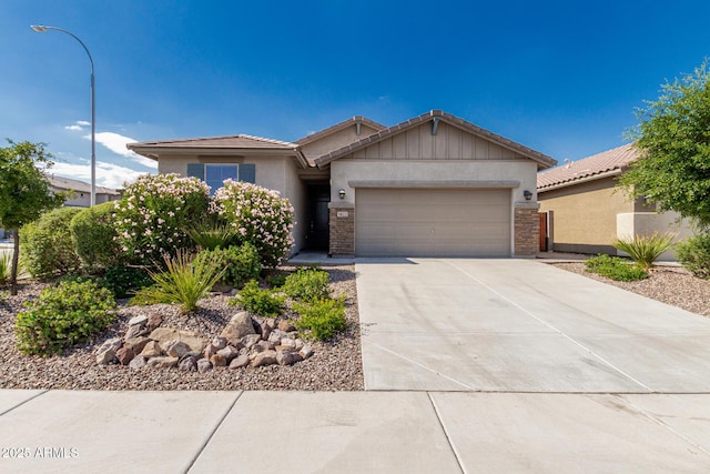 9822 W Caron Dr, Peoria, AZ 85345 - view of front of home featuring an attached garage, concrete driveway, stucco siding, a tile roof, and stone siding