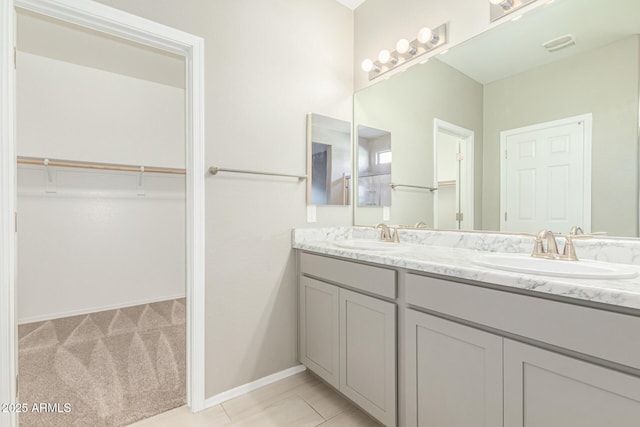 9822 W Caron Dr, Peoria, AZ 85345 - full bath with double vanity, a walk in closet, and baseboards