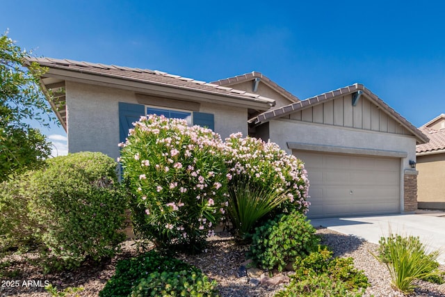 9822 W Caron Dr, Peoria, AZ 85345 - view of front facade featuring a garage, concrete driveway, a tile roof, and stucco siding