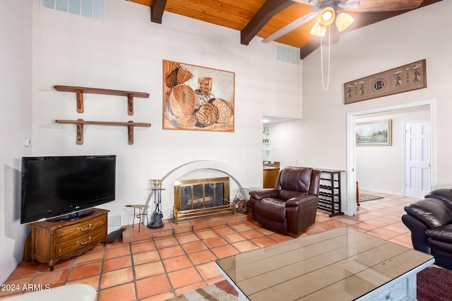 36444 N Stardust Ln, Carefree, AZ 85377 - tiled living room with beam ceiling, ceiling fan, wooden ceiling, a glass covered fireplace, and a towering ceiling