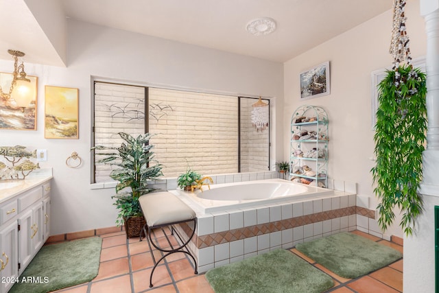 bathroom with tile patterned flooring, vanity, and a relaxing tiled tub