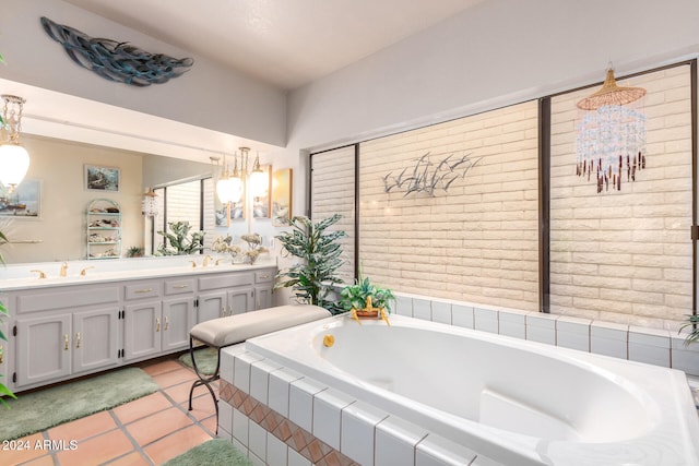 bathroom with tile patterned flooring, vanity, a relaxing tiled tub, and an inviting chandelier