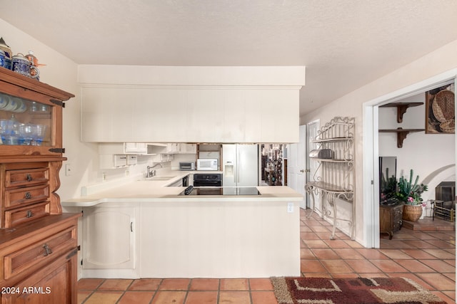 kitchen with white cabinets, kitchen peninsula, and white appliances