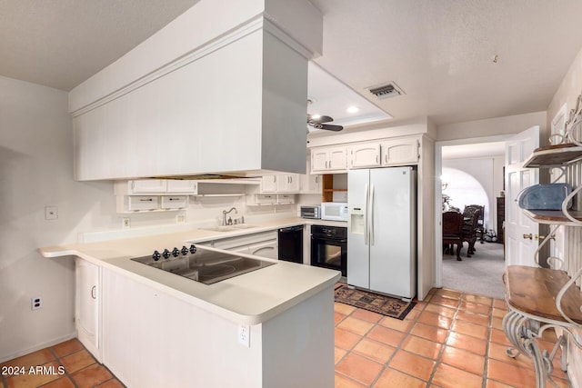 36444 N Stardust Ln, Carefree, AZ 85377 - kitchen with black appliances, a peninsula, a sink, light countertops, and white cabinets