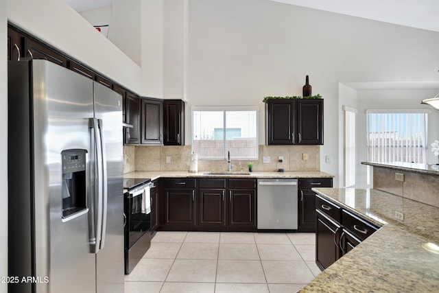4329 W Electra Ln, Glendale, AZ 85310 - kitchen featuring stainless steel appliances, a sink, light tile patterned floors, tasteful backsplash, and a high ceiling