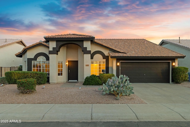 4329 W Electra Ln, Glendale, AZ 85310 - mediterranean / spanish-style house with an attached garage, stucco siding, a tiled roof, and concrete driveway