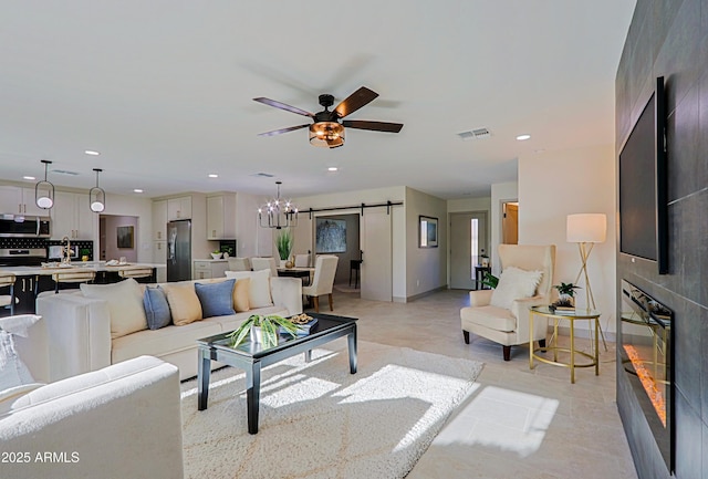 living room with recessed lighting, a large fireplace, visible vents, and a barn door