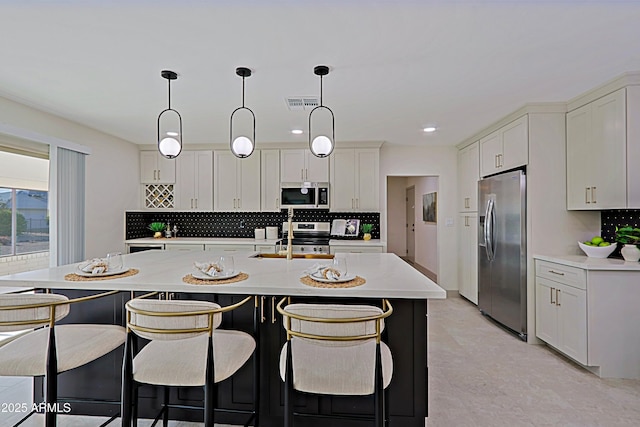 kitchen with backsplash, stainless steel appliances, a sink, and light countertops