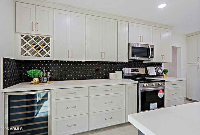 kitchen featuring recessed lighting, beverage cooler, white cabinetry, appliances with stainless steel finishes, and tasteful backsplash