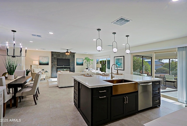 kitchen featuring visible vents, a sink, stainless steel dishwasher, and dark cabinetry