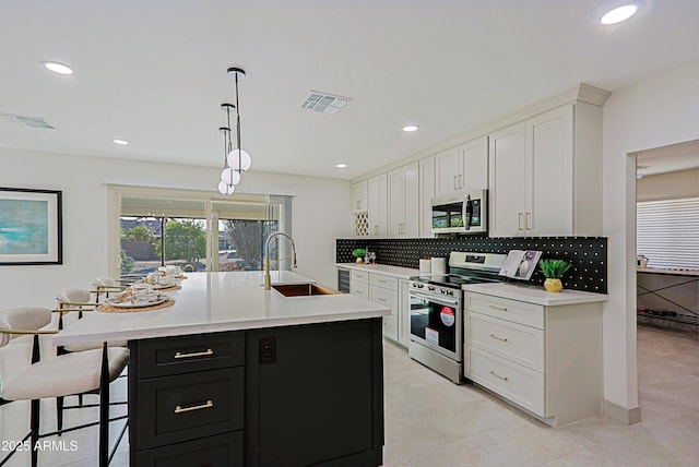 kitchen featuring a sink, visible vents, white cabinets, light countertops, and appliances with stainless steel finishes