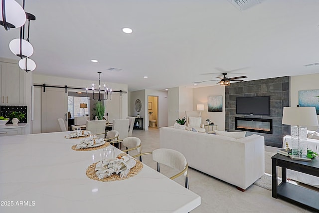 dining area featuring a barn door, a fireplace, visible vents, and recessed lighting