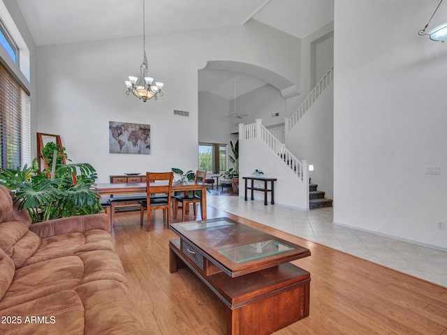 40814 N Majesty Ct, Anthem, AZ 85086 - living room with high vaulted ceiling, a ceiling fan, stairs, a chandelier, and arched walkways