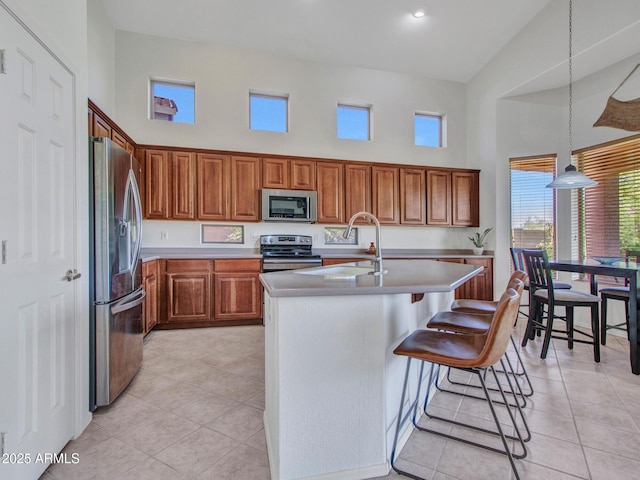 40814 N Majesty Ct, Anthem, AZ 85086 - kitchen with appliances with stainless steel finishes, brown cabinets, a towering ceiling, light countertops, and light tile patterned floors