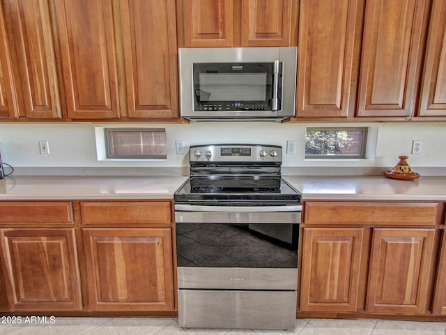 40814 N Majesty Ct, Anthem, AZ 85086 - kitchen with stainless steel appliances, light countertops, and light tile patterned flooring