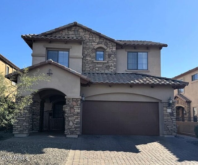 view of front of home with a garage, stone siding, decorative driveway, and stucco siding