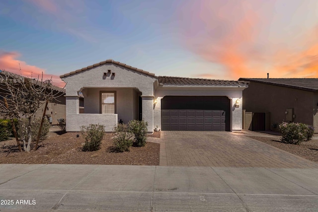 19958 W Turney Ave, Litchfield Park, AZ 85340 - view of front of home featuring a tiled roof, a garage, stucco siding, and decorative driveway