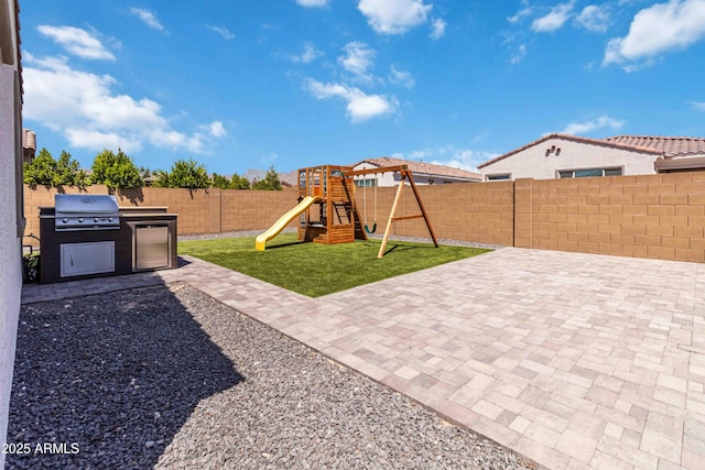 19958 W Turney Ave, Litchfield Park, AZ 85340 - view of yard featuring a patio, an outdoor kitchen, a fenced backyard, and a playground