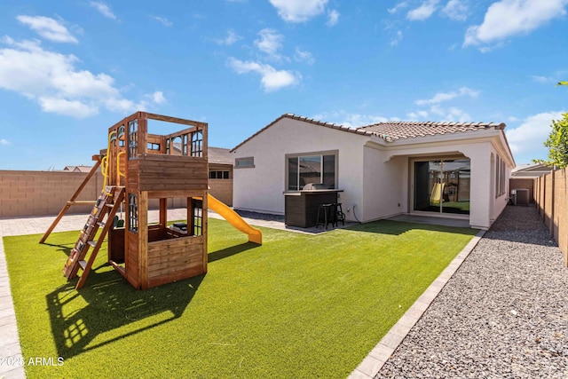 19958 W Turney Ave, Litchfield Park, AZ 85340 - back of property with a tiled roof, a fenced backyard, stucco siding, a lawn, and a playground