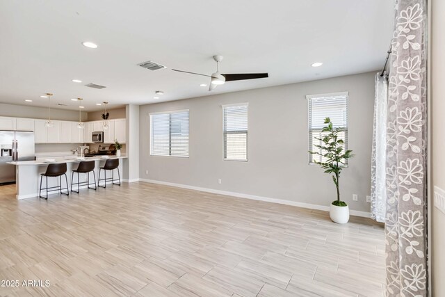 19958 W Turney Ave, Litchfield Park, AZ 85340 - unfurnished living room with baseboards, a ceiling fan, visible vents, and recessed lighting