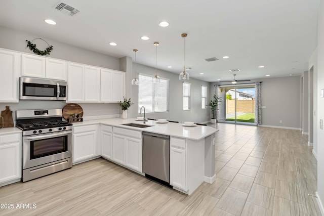 19958 W Turney Ave, Litchfield Park, AZ 85340 - kitchen with visible vents, a sink, open floor plan, a peninsula, and stainless steel appliances
