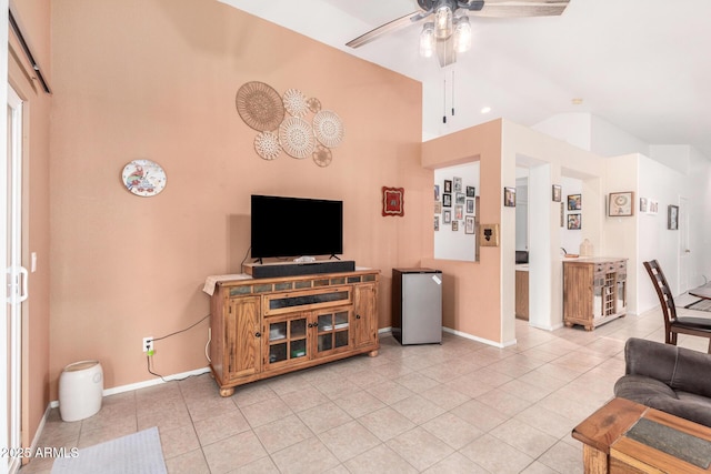 living room featuring lofted ceiling, ceiling fan, baseboards, and light tile patterned floors