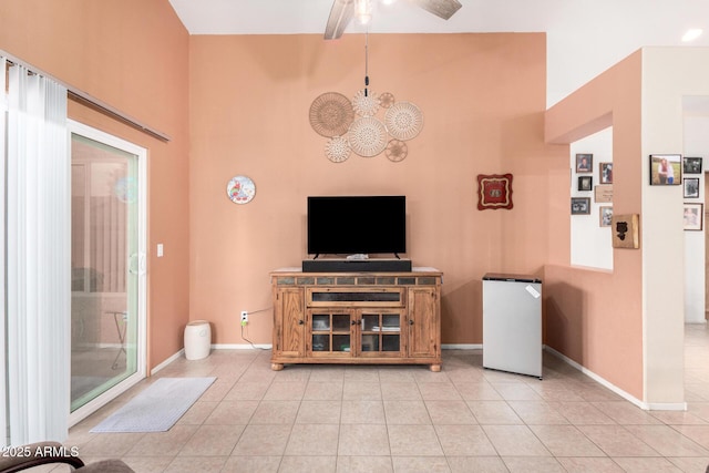 living area with light tile patterned floors, baseboards, and a ceiling fan