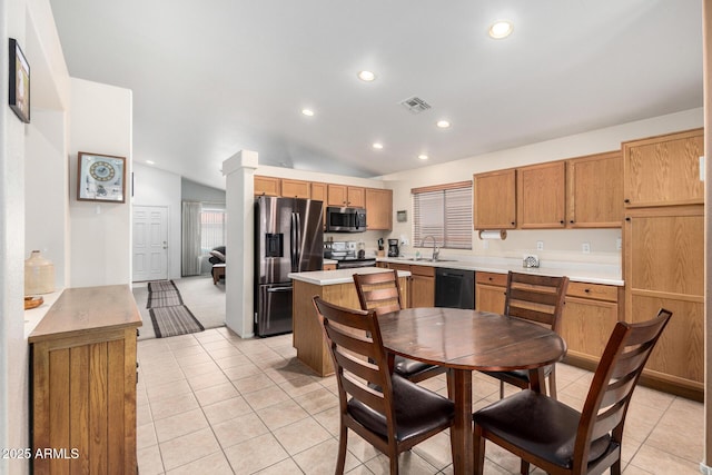 kitchen with a sink, visible vents, vaulted ceiling, light countertops, and appliances with stainless steel finishes