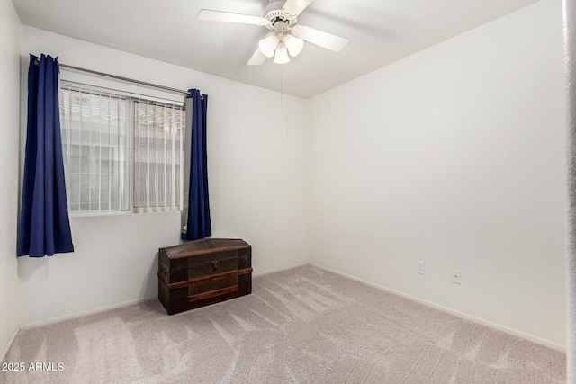 empty room featuring ceiling fan, carpet floors, and baseboards